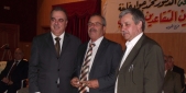 خلفية يسلم أحد المكرمين درعا تقديريا آخر