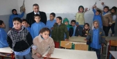 تلامذة مدرسة حلتا يشيرون إلى تصدعات جدار في غرفة الصف